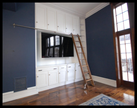 12ft high white entertainment center with mission style cabinetry, widescreen TV area, and custom rolling library ladder.