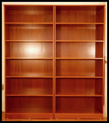 A pair of handcrafted Sapele wood freestanding bookcases, custom-built to client specifications with thick shelving and integrated anti-tip safety anchors.