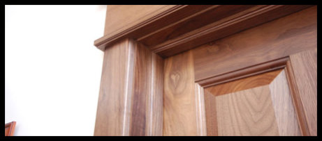 Close-up detail of a premium handcrafted Walnut door and frame, a premier example of the custom craftsmanship praised by our clients.
