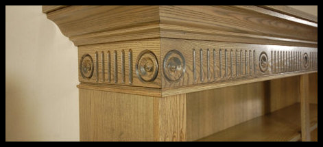 Premier showcase of a handcrafted freestanding bookcase featuring elegant rosettes, fluted moldings, and custom crown molding.