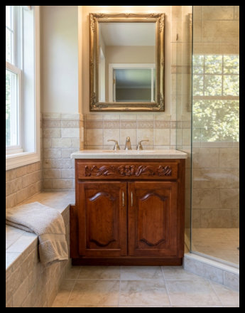 High-end custom Cherry wood bathroom vanity featuring deep-stained raised panel doors with arched details and a decorative hand-scrolled wood header.