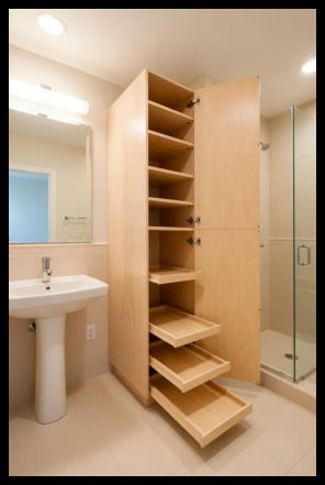 Custom maple linen tower with upper shelving and lower sliding trays; finished in clear-coated A1 veneer core maple.