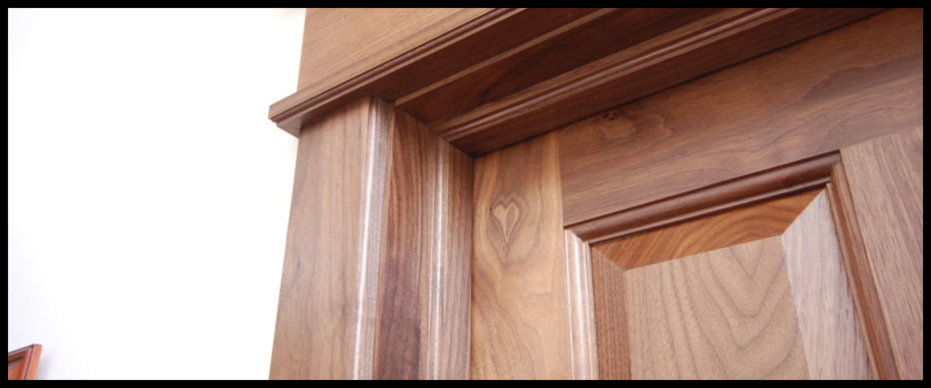 Close-up detail of a premium handcrafted Walnut door and frame, a premier example of the custom craftsmanship praised by our clients.