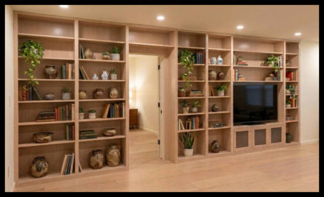 Custom built-in bookcases and entertainment center featuring 2-inch vertical dividers, stained in ZAR Beach House, scribed for a level fit in a finished basement.