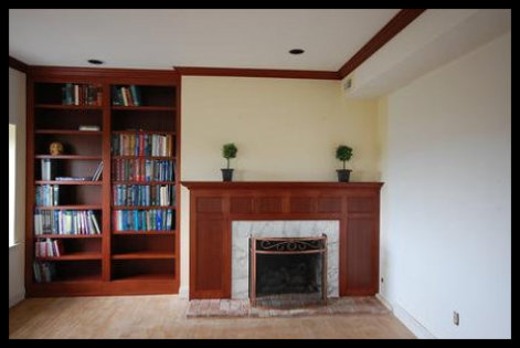 Custom floor-to-ceiling Sapele hard wood built-in library, including twin bookcases with LED lighting, seamlessly integrated with a matching fireplace mantle and surround paneling.